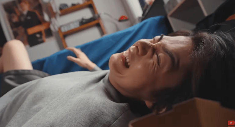 Baku waking up in pain in his bedroom after falling from the dream world in Kamen Rider Zeztz Episode 16