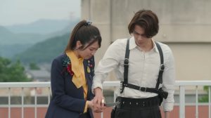 Nem holds a knife as Baku gently stops her in Kamen Rider Zeztz episode 19 during a moment of emotional crisis