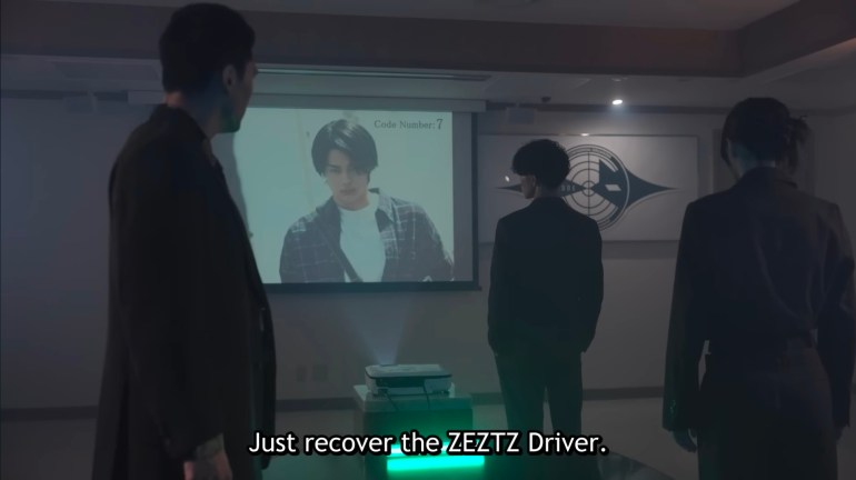 CODE agents receiving orders to recover the Zeztz Driver in Kamen Rider Zeztz Episode 26 while viewing Baku's profile labeled Code Number 7.