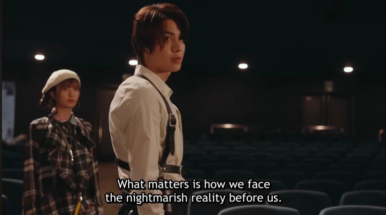 Baku Yorozu speaks to Nem inside an empty theater about facing the nightmarish reality of the Nightmare threat in Kamen Rider Zeztz Episode 26.