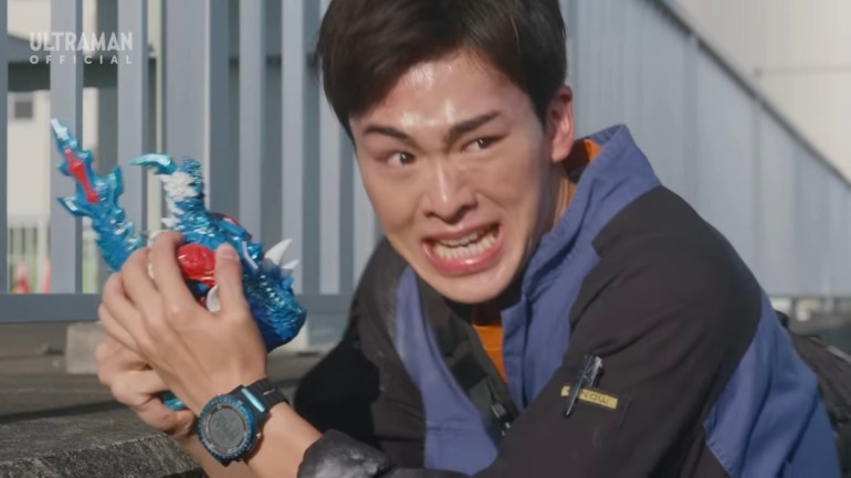Kosei Hoshimi reacting fearfully in Ultraman Omega Episode 11 while holding the Rekiness figure