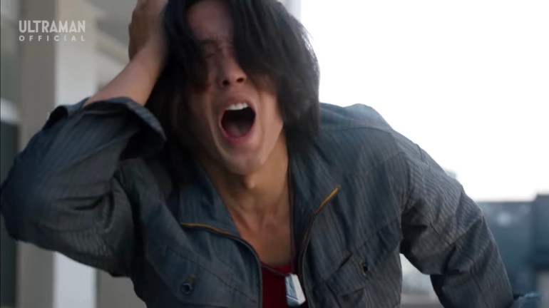 Sorato clutches his head in pain during Ultraman Omega Episode 14 as fragments of his lost memories begin returning, leaving him vulnerable during his confrontation with Zovaras.