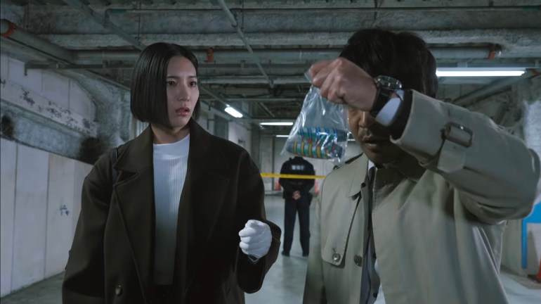 Nasuka Nagumo and Tetsuya Fujimi investigate a Black Case crime scene in Kamen Rider Zeztz 39 as Fujimi examines mysterious evidence connected to Nightmare activity.