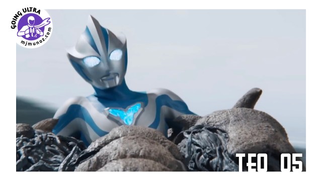 Ultraman Teo holds a gray tentacle kaiju by its legs while spinning it during their battle.