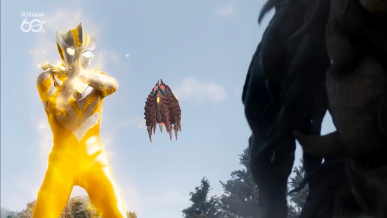 Ultraman Teo charges his finishing beam while Kanna floats between him and the tentacle kaiju during their confrontation.