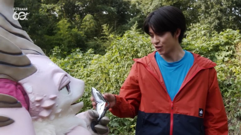 Pucchi holds out the Cryar to Ibuki as he reaches to take it during Ultraman Teo 05.