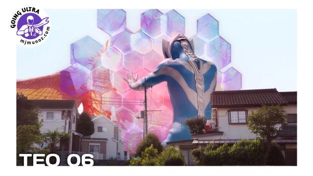 Ultraman Teo raises a glowing hexagonal barrier against the giant bird kaiju Vermilios among houses in a residential neighborhood.