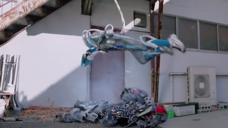 Kamen Rider My-Th hangs from a metal stairway using his tail.